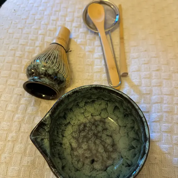 Green matcha set resting on a white plaid blanket